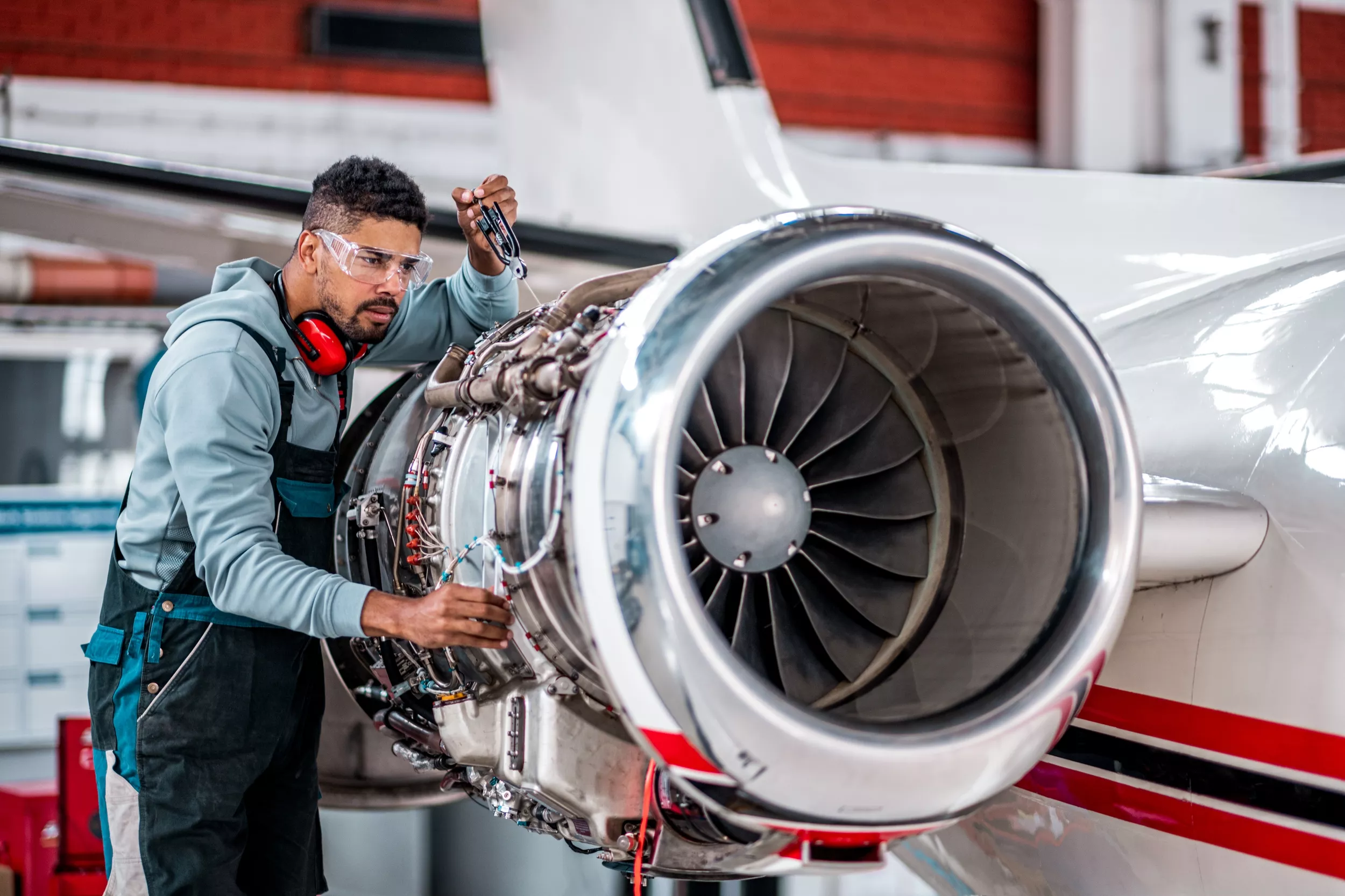 Mechanic looks down side of plane .