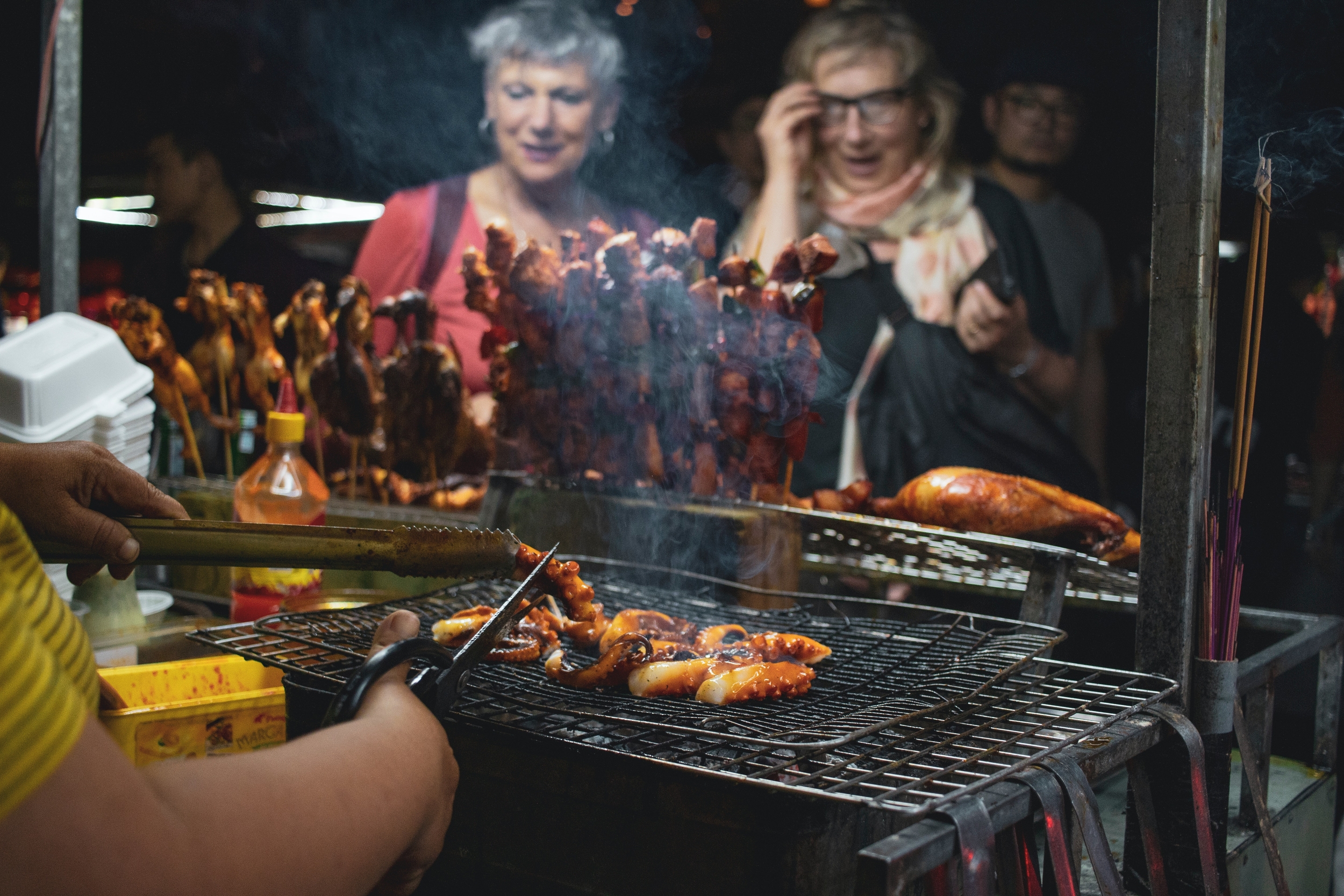 Women purchasing kabobs.