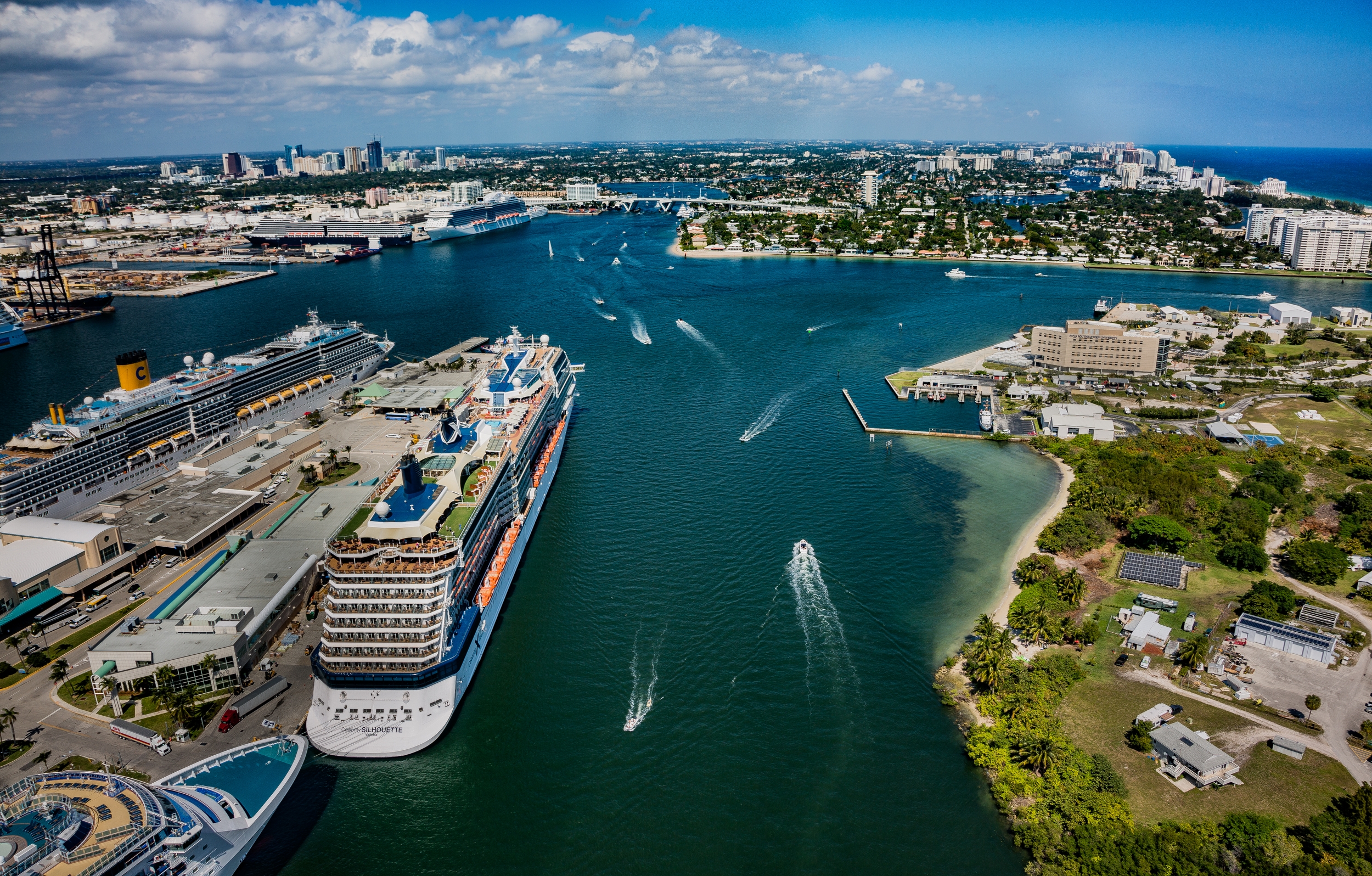 Cruise ship enters frame and heads into city .