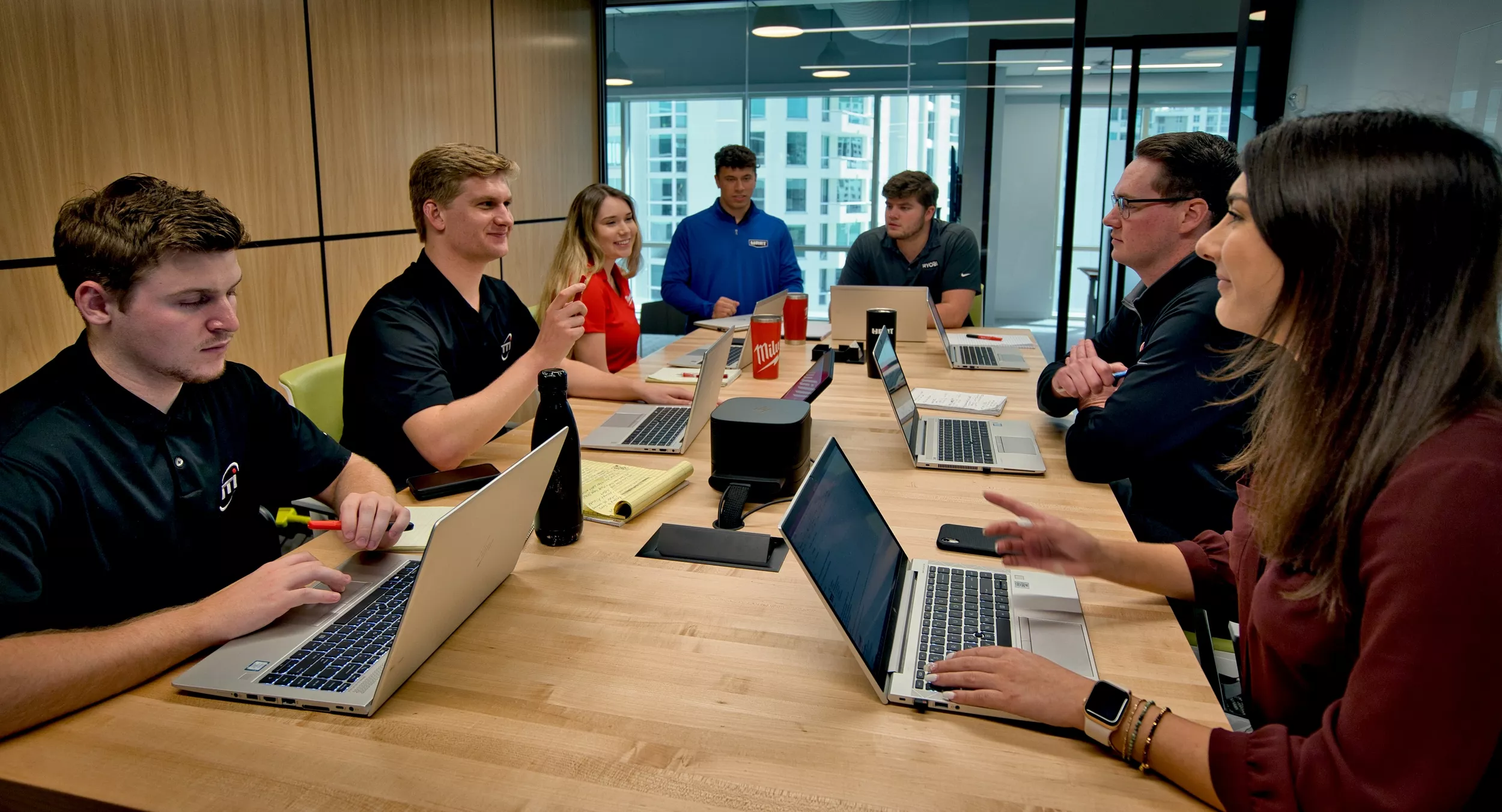 Boardroom meeting with employees smiling and conversing.