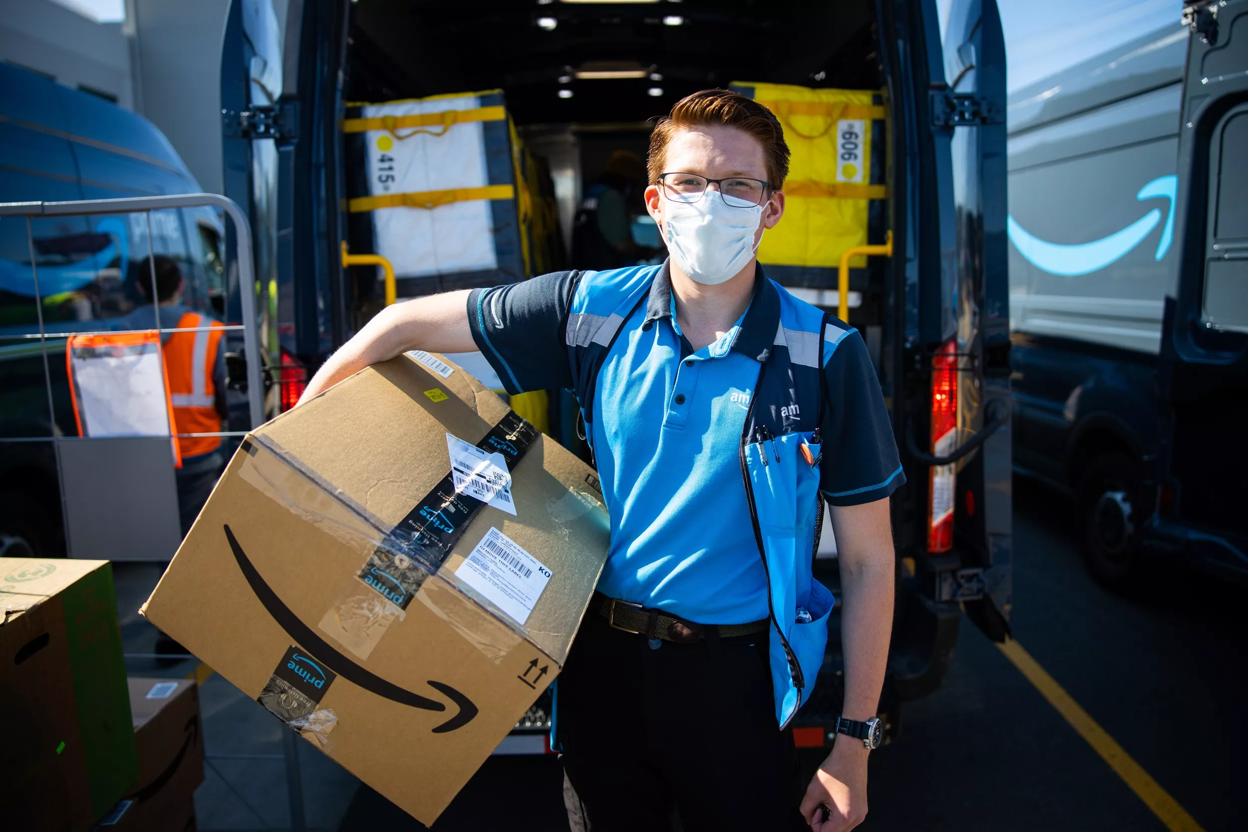 Male amazon employee holding package.