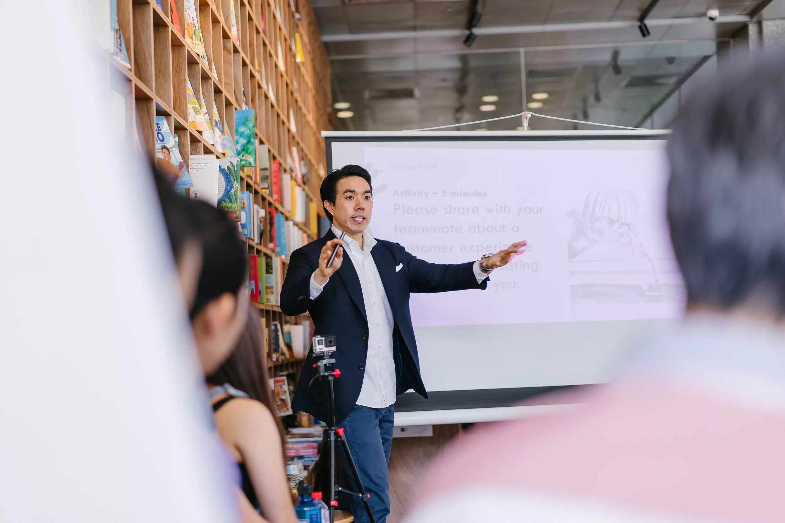 Man presenting to group in front of a whiteboard.